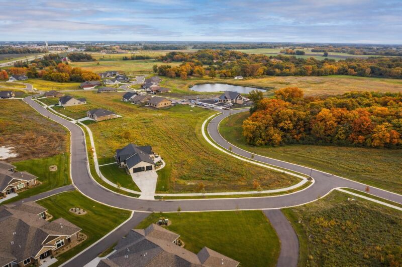 Aerial view of Siesta Hills planned residential neighborhood in Mankato Minnesota showing curved streets, open land, and pond feature.