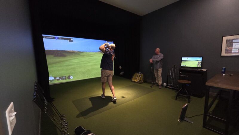 Resident using indoor golf simulator at Siesta Hills clubhouse in Mankato Minnesota