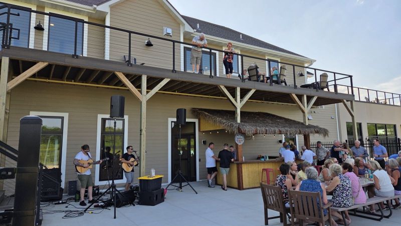 Residents enjoying live music and socializing at a community event outside the Siesta Hills Clubhouse in Mankato, Minnesota