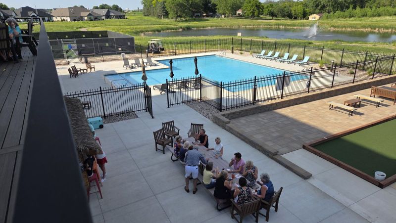 Residents enjoying a social gathering near the outdoor pool and bocce court at Siesta Hills in Mankato, Minnesota