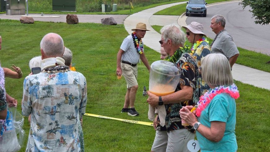 Siesta Hills resident bringing Mai Tai refills to neighbors during the 2026 Hawaiian luau yard games