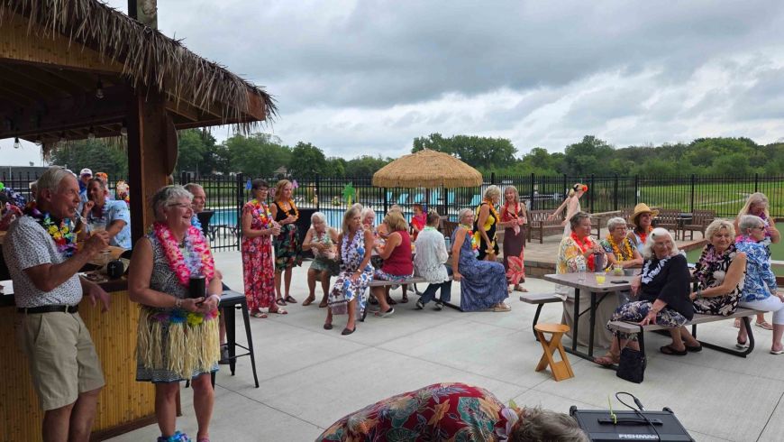 Siesta Hills residents gathering around the tiki hut and clubhouse patio during the 2026 Hawaiian luau