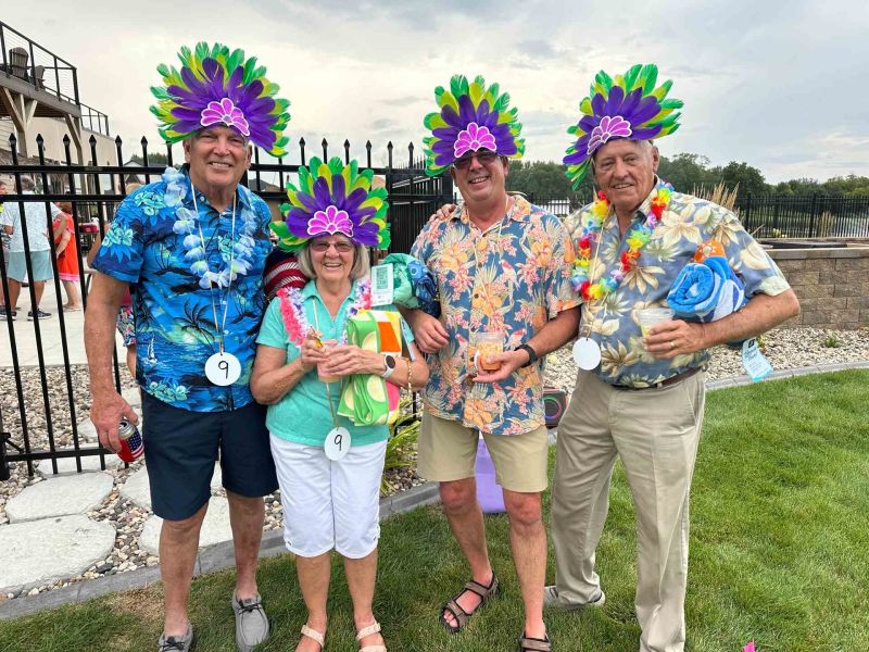 Siesta Hills neighbors wearing colorful Hawaiian shirts, leis and festive hats during a community luau