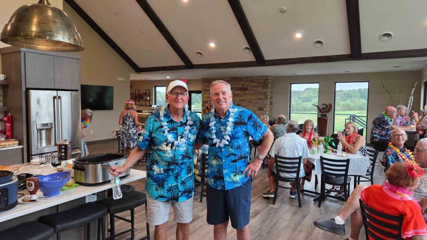 Two Siesta Hills residents wearing matching Hawaiian shirts at the 2026 community luau